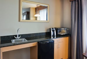 A compact kitchenette with a sink, a microwave, and a coffee maker.
