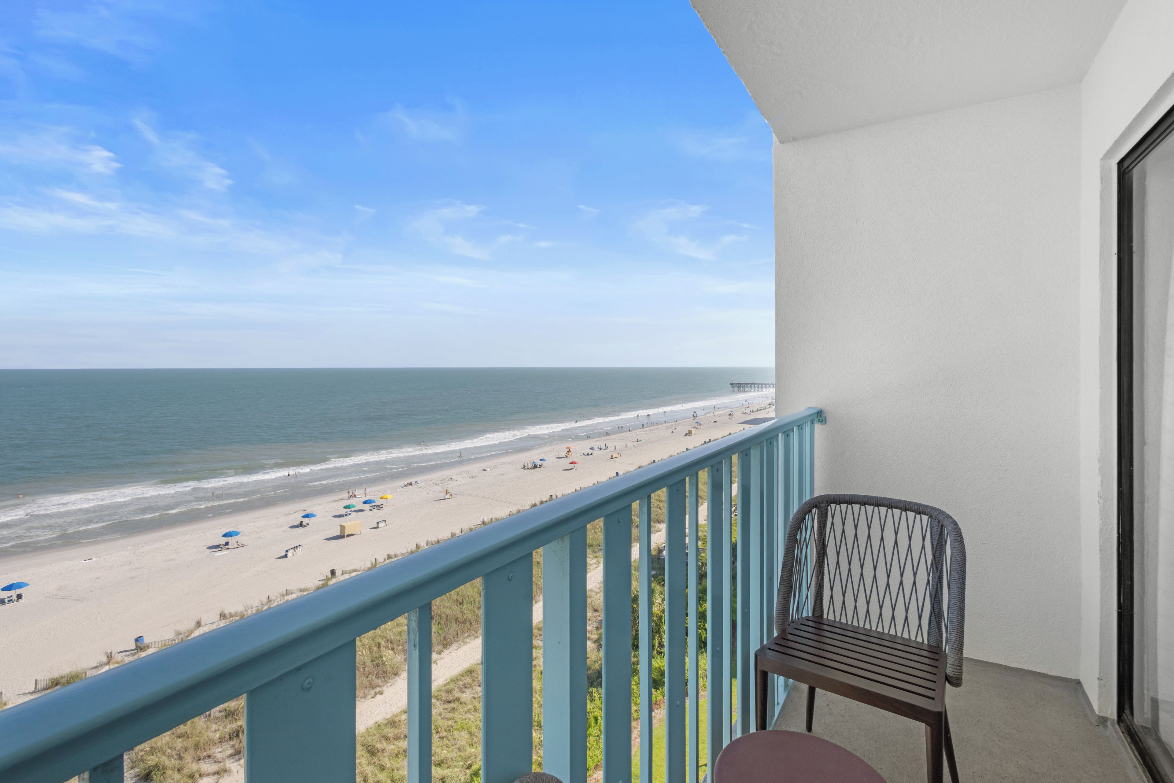 A balcony with a view of a beach and ocean.