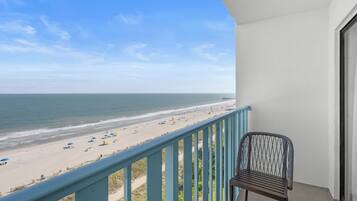 Ein Balkon mit Blick auf Strand und Meer.