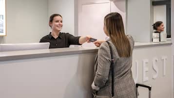 A reception desk with a person handing over a card to another person.