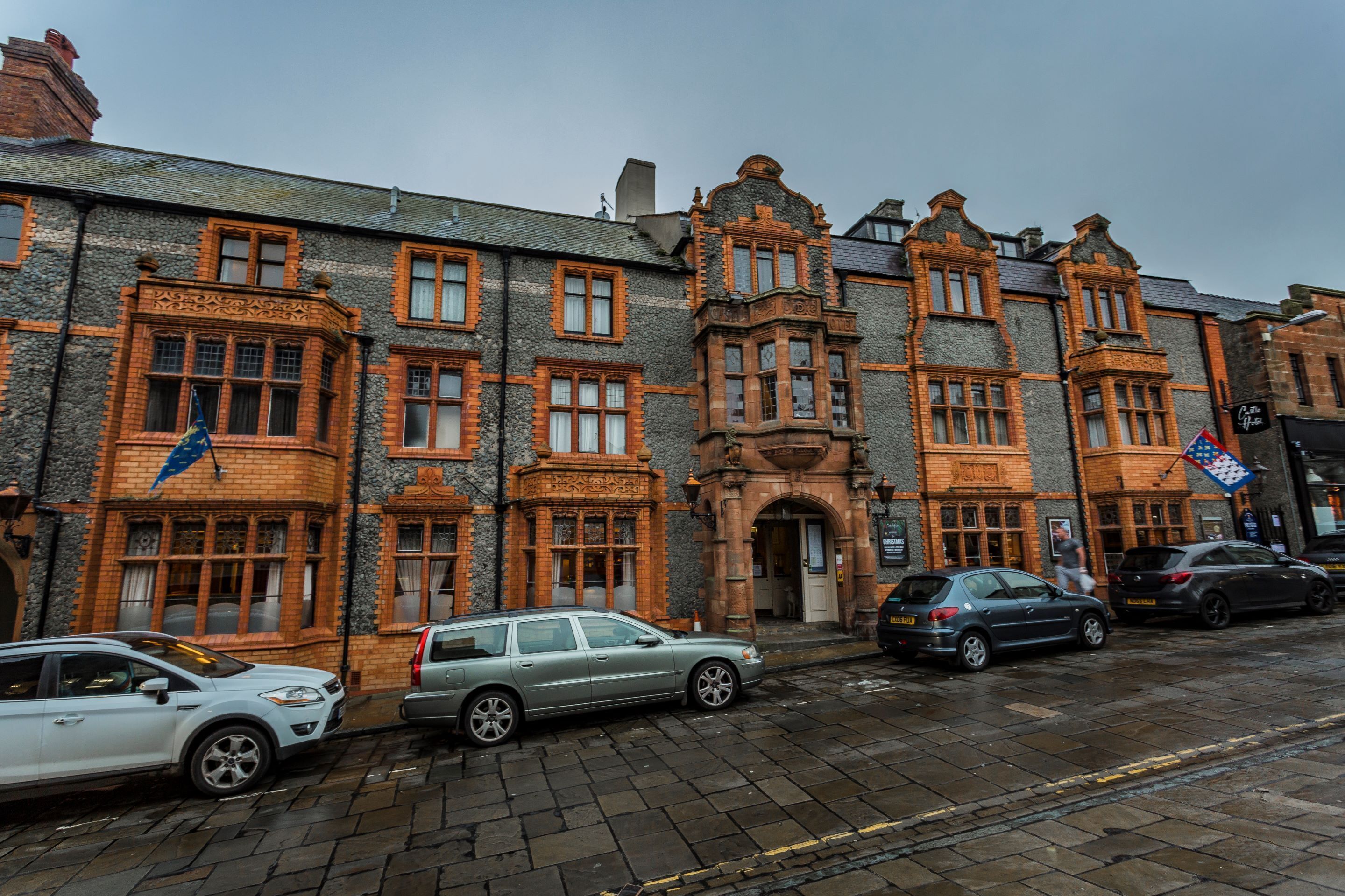 A row of historic buildings with ornate brickwork and large windows.