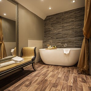 A modern bathroom with a freestanding bathtub, a large mirror, and a wooden floor. - The Castle Hotel, Conwy, North Wales (Conwy)