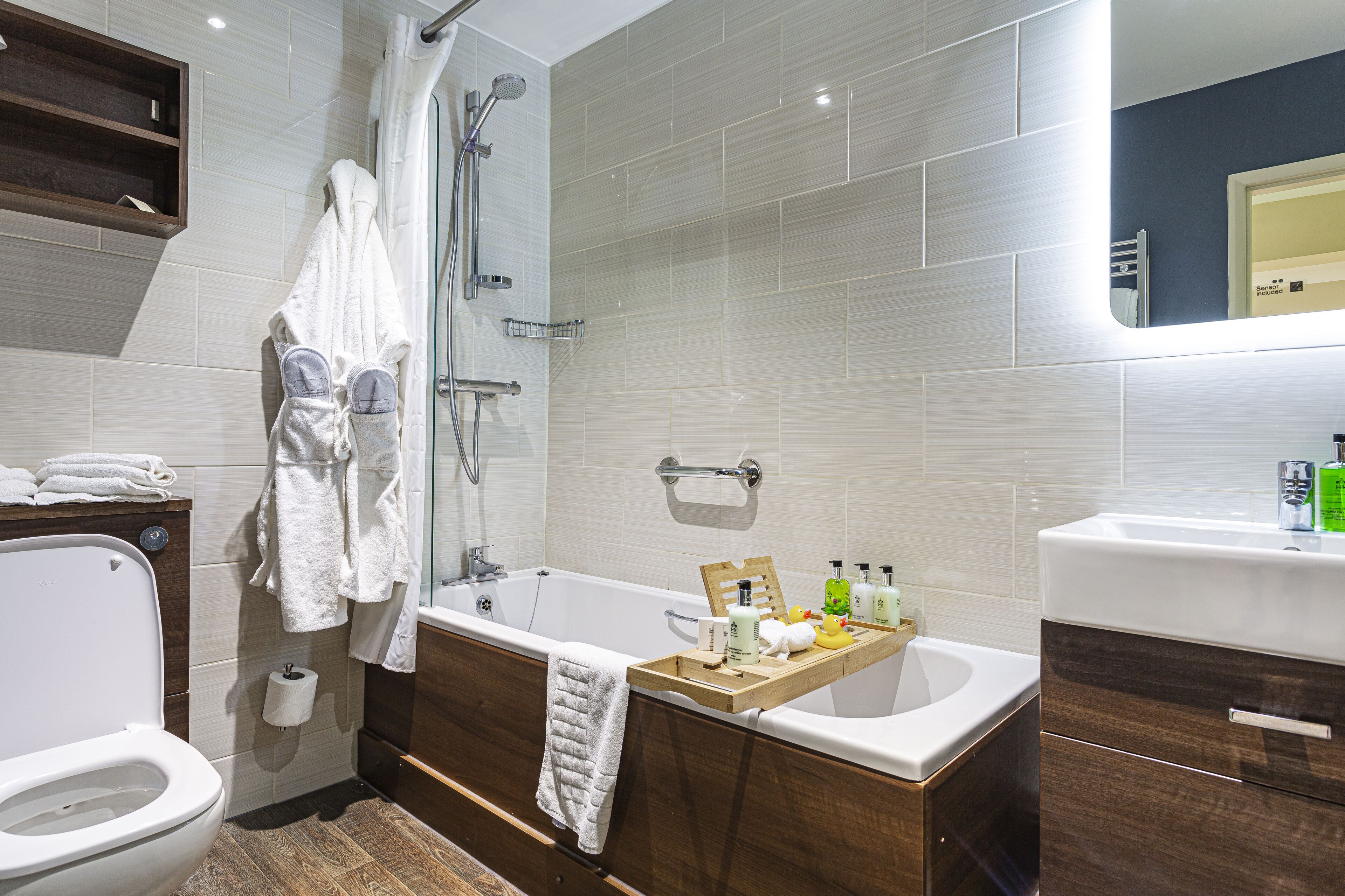 A modern bathroom with a bathtub, shower, toilet, and vanity.