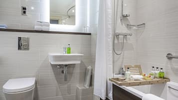 A modern bathroom with a toilet, sink, shower, and bathtub.