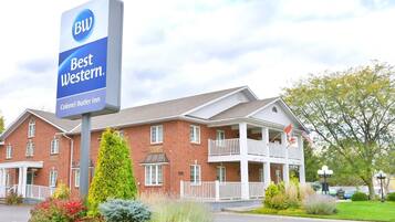 Een Best Western hotel met een bakstenen gevel, meerdere balkons en een verzorgd gazon.