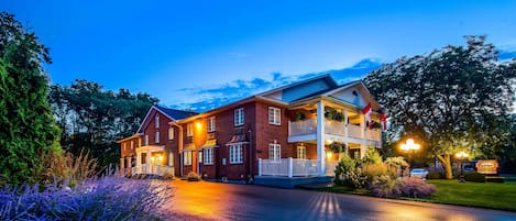 Vista frontal de la propiedad por la tarde o noche