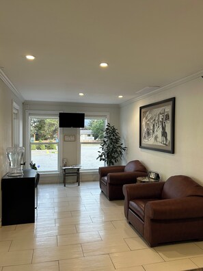 A living room with a sofa, a coffee table, a TV, and a framed picture on the wall.