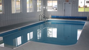 An indoor swimming pool with clear glass walls, a ladder, and a door marked "EXIT ALLOWED". - Sage Inn Merritt (Merritt)