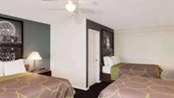Habitación de hotel con dos camas, ventilador de techo y un cuadro en la pared.