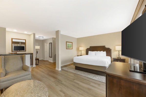 A hotel room with a bed, a TV, a sofa, and a desk.