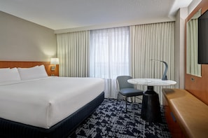 A hotel room with a large bed, a desk with a chair, a television, and a window with curtains. - Embassy Suites by Hilton Washington D.C. – Convention Center (Washington)