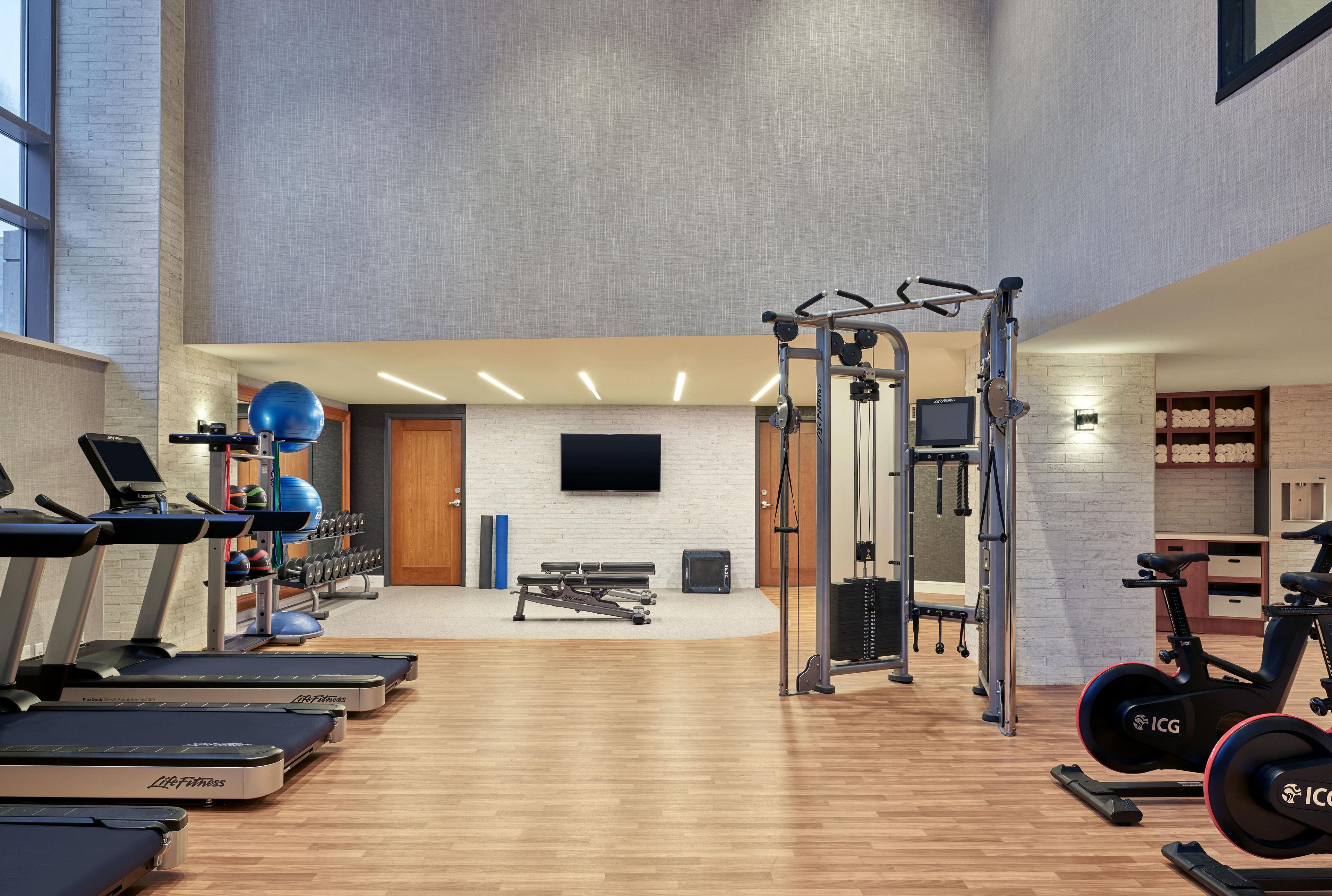 A gym with treadmills, weight machines, and exercise balls.