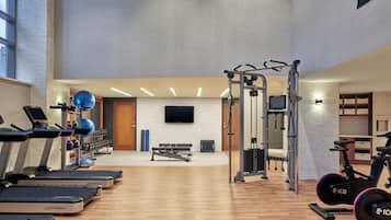 A gym with treadmills, weight machines, and exercise balls.