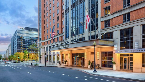 A hotel with a brick facade, large windows, and an American flag. - Embassy Suites by Hilton Washington D.C. – Convention Center (Washington)