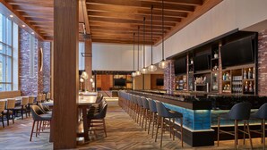 A modern bar area with a long counter, multiple TVs, and a variety of bottles. - Embassy Suites by Hilton Washington D.C. – Convention Center (Washington)