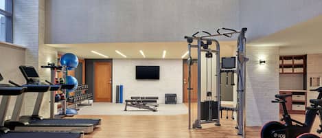 A gym with treadmills, weight machines, and exercise balls.