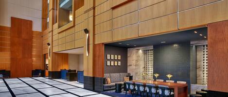 A spacious lobby with a reception desk, seating area, and a dining table with chairs.