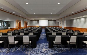 A conference room with rows of tables and chairs, a large screen, and a carpeted floor. - Embassy Suites by Hilton Washington D.C. – Convention Center (Washington)