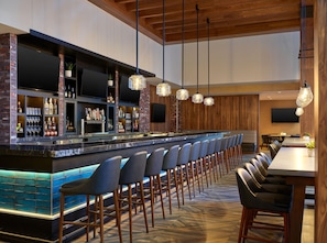 A bar area with a long counter, multiple seating options, and a television mounted on the wall. - Embassy Suites by Hilton Washington D.C. – Convention Center (Washington)