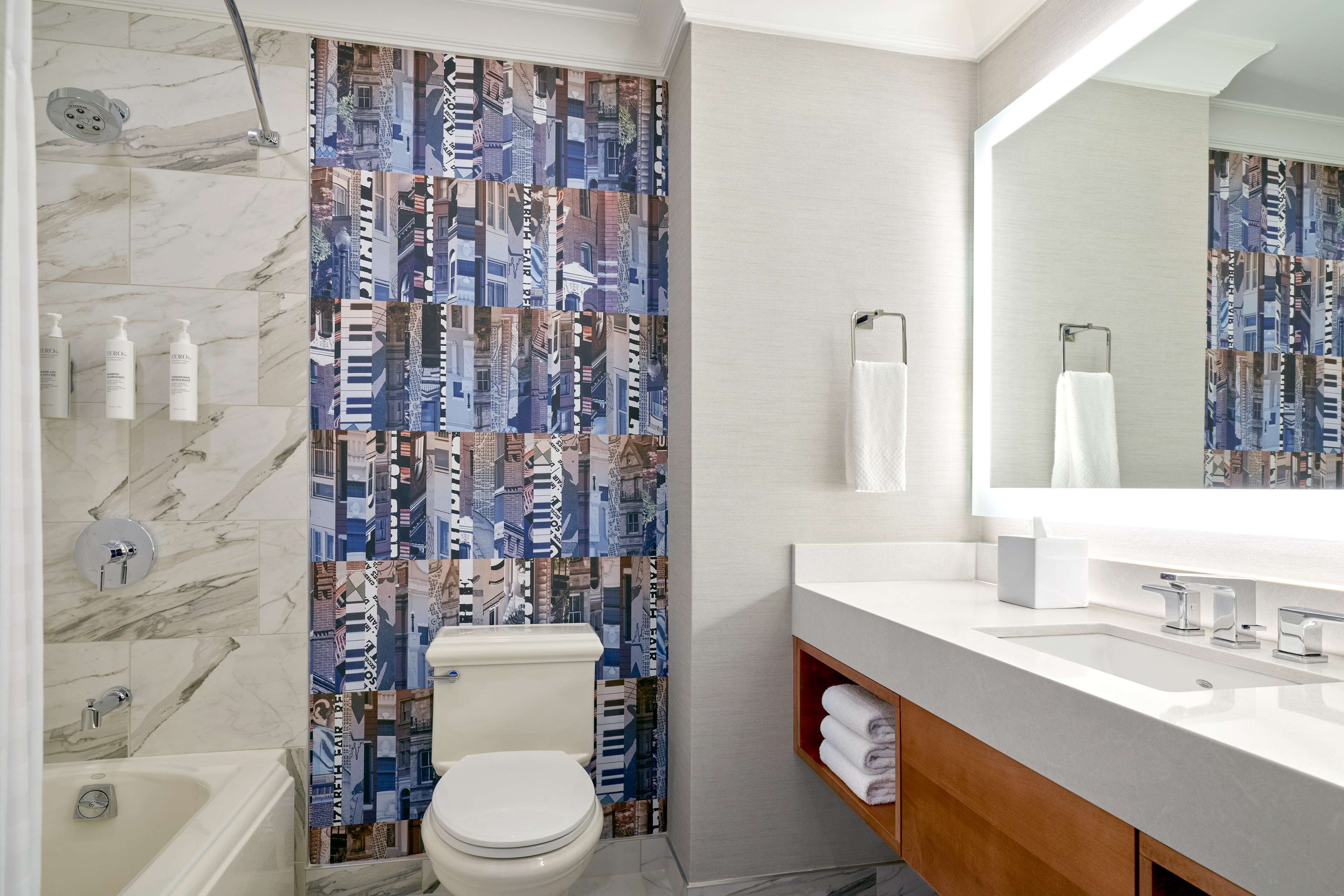 A modern bathroom with a toilet, shower, and sink.