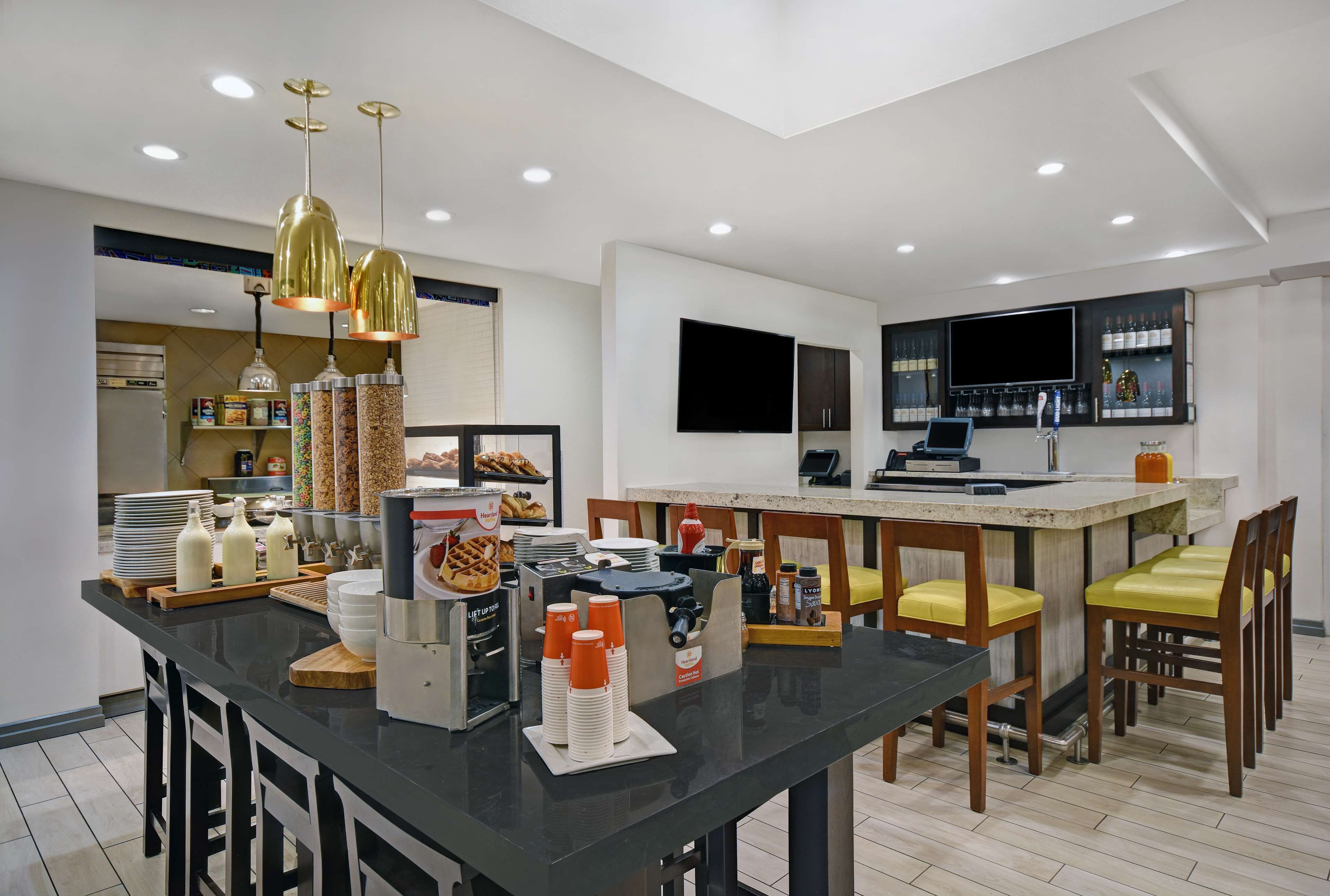 Una cocina moderna con una isla central, barra y asientos.