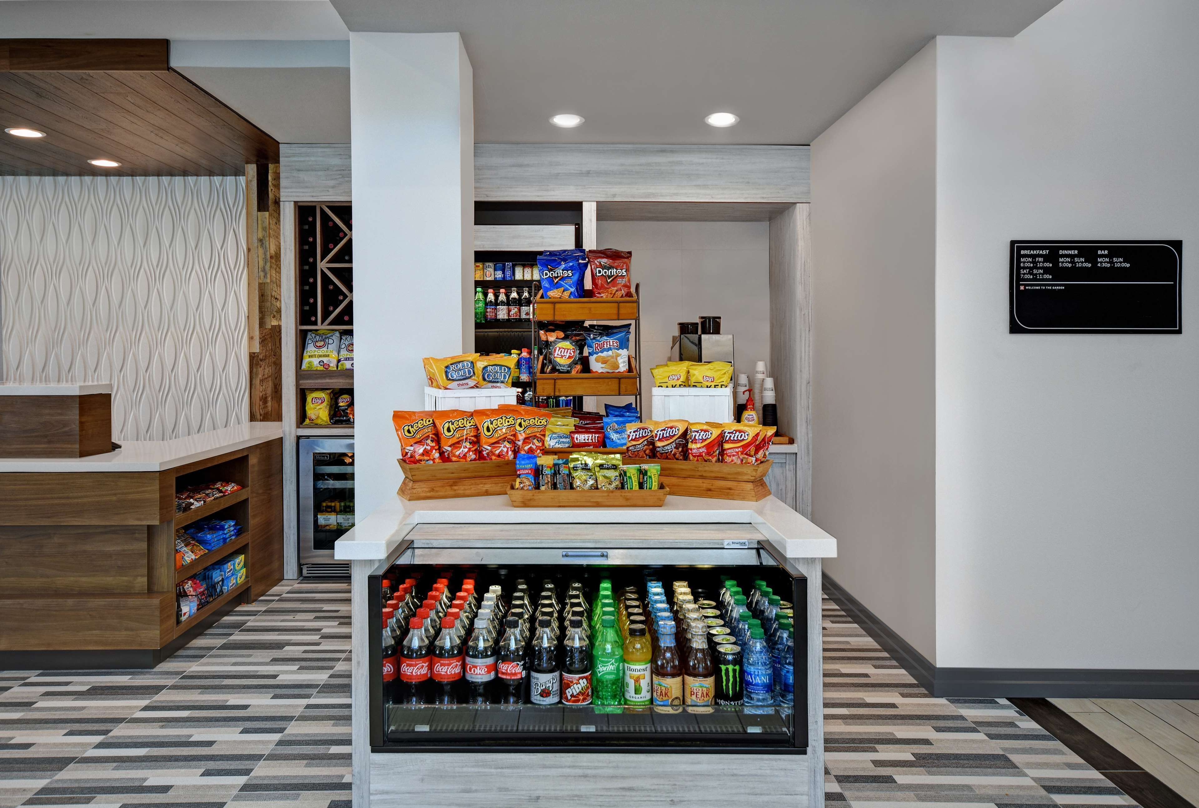 A snack display with various chips and a refrigerated beverage section.