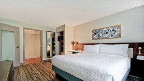 A hotel room with a large bed, a desk, a chair, a wardrobe, and a bathroom. - Hilton Garden Inn Houston/Galleria Area (Houston)