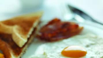 A breakfast plate with toast, bacon, and eggs.