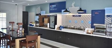 Una cocina moderna con barra de desayuno, estación de café y un cartel que indica servicio de desayuno.