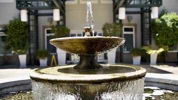 A fountain with water spouting from the top, surrounded by a circular pool.