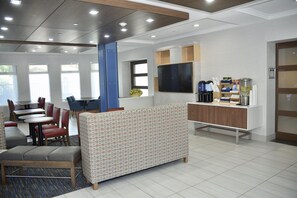 A modern hotel lobby with a seating area, a TV, and a coffee station. - Holiday Inn Express® Windsor Sonoma Wine Country by IHG (Windsor)