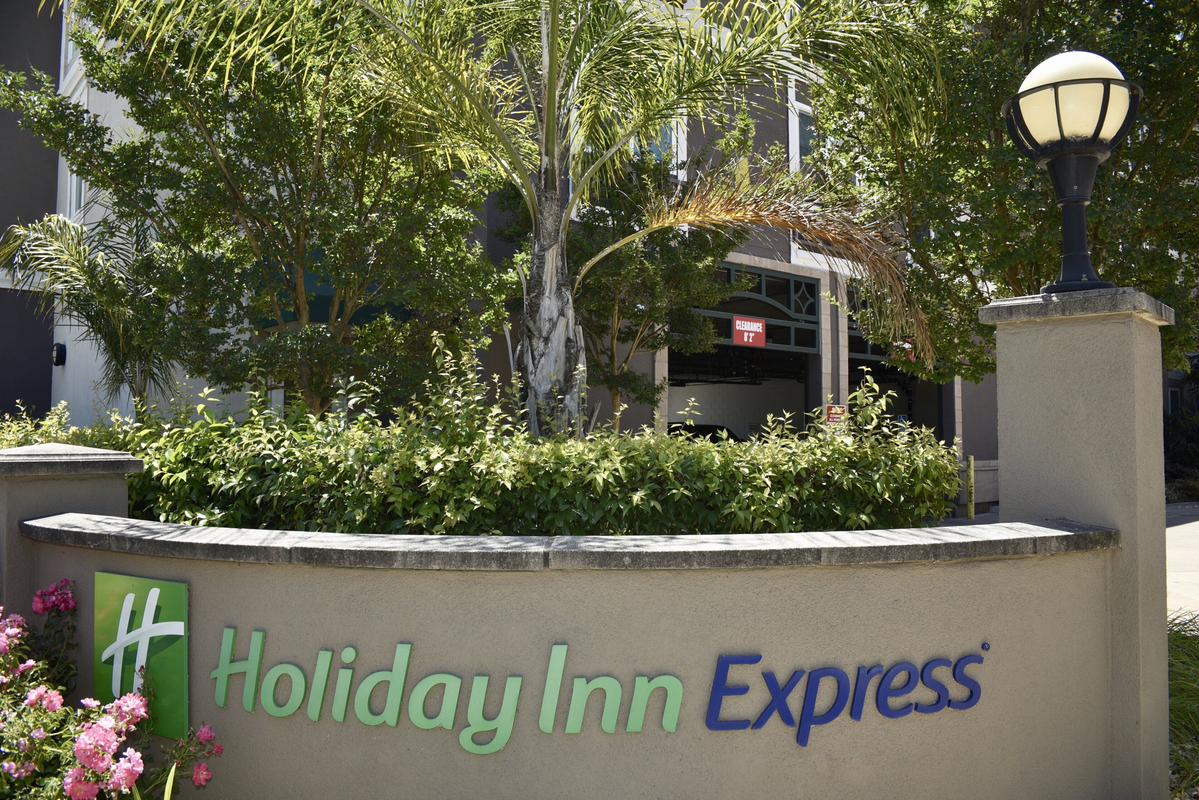 A sign for Holiday Inn Express with a clear view of the building's entrance and surrounding greenery.