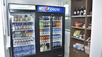Zona de máquinas expendedoras con un refrigerador de Pepsi y un refrigerador de HelloGoodness.
