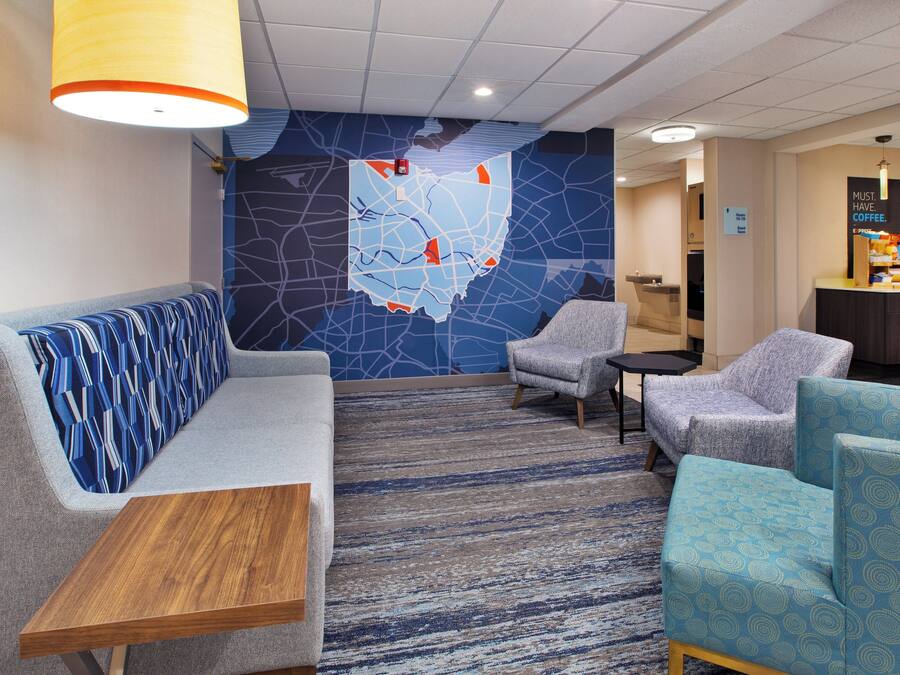 A lobby with seating areas, a coffee station, and a map on the wall.