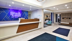 A hotel reception area with a modern design, including a reception desk, seating area, and a fireplace. - Holiday Inn Express & Suites Kent - University Area by IHG (Kent)