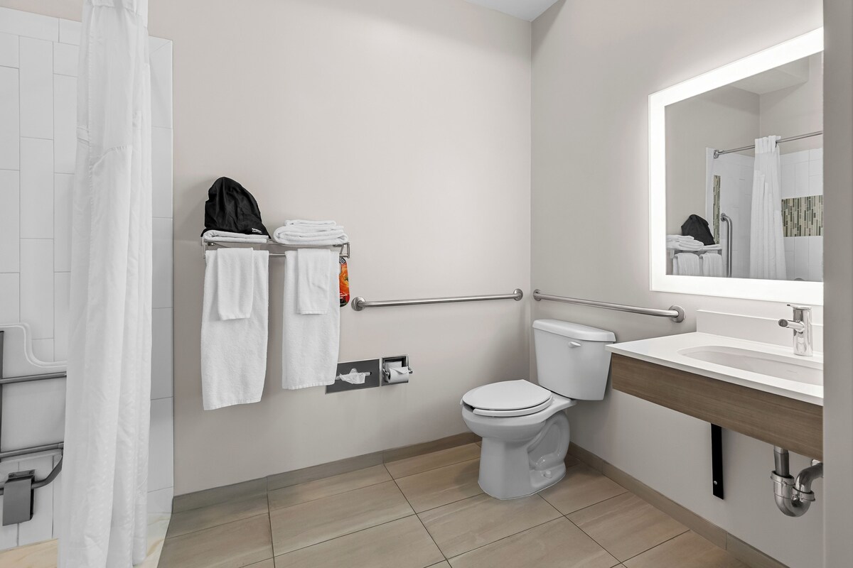 A modern bathroom with a toilet, sink, and towel rack.