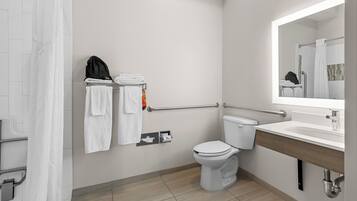 Une salle de bain moderne équipée de toilettes, d’un lavabo et d’un porte-serviettes.