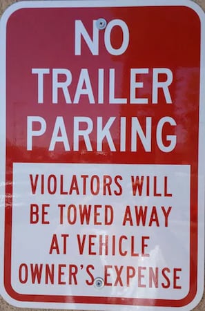 A red and white no trailer parking sign with a warning that violators will be towed at their own expense. - Holiday Inn Express & Suites Alamosa by IHG (Alamosa)