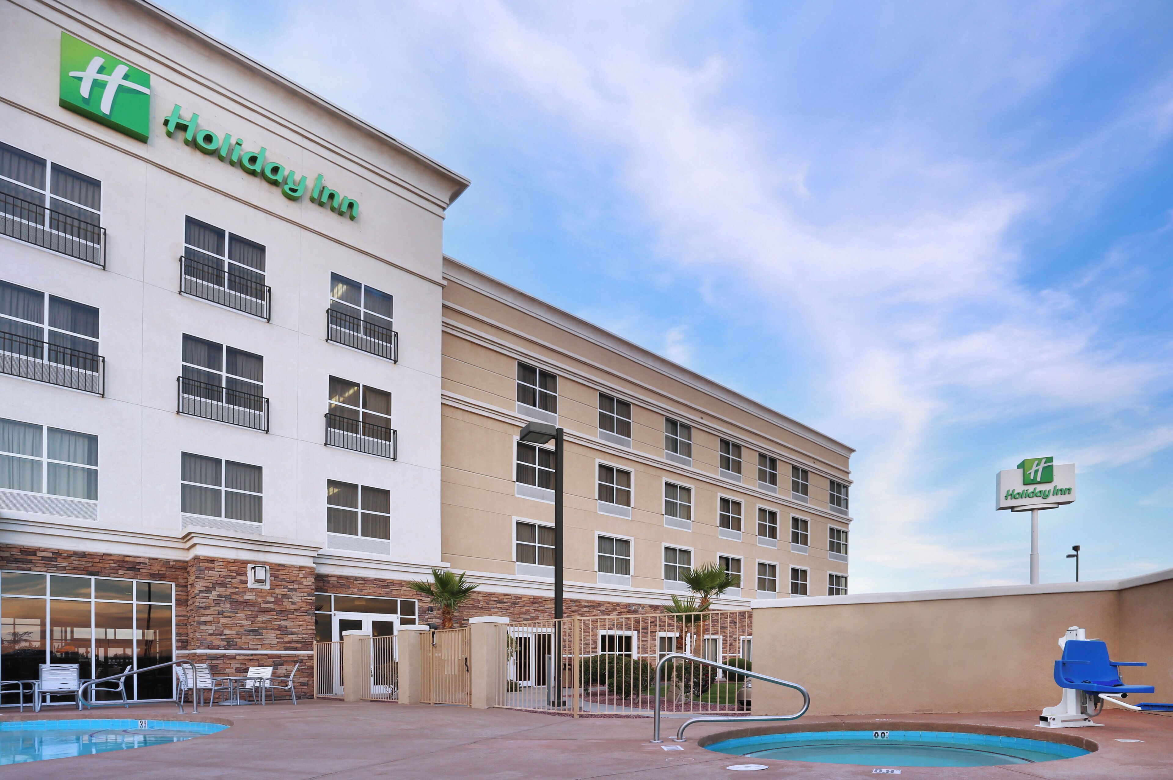 Un hotel Holiday Inn con piscina y zona de estar al aire libre.
