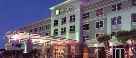 A Holiday Inn hotel with a covered entrance, multiple floors, and a parking area.
