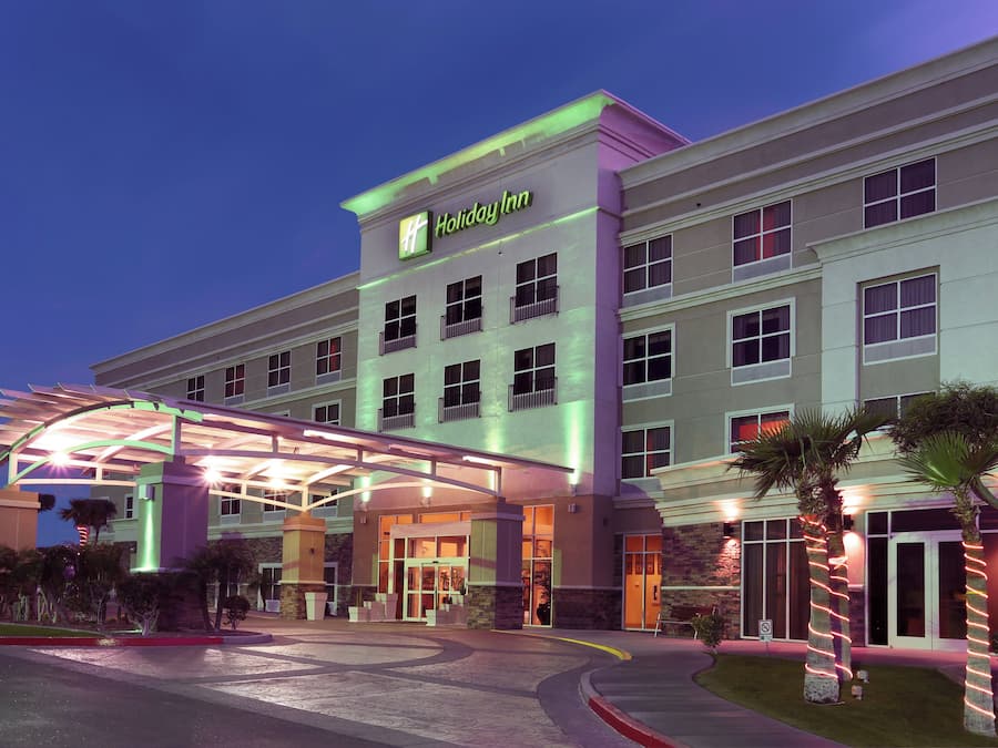 Et Holiday Inn hotel med overdækket indgang, flere etager og parkeringsplads.