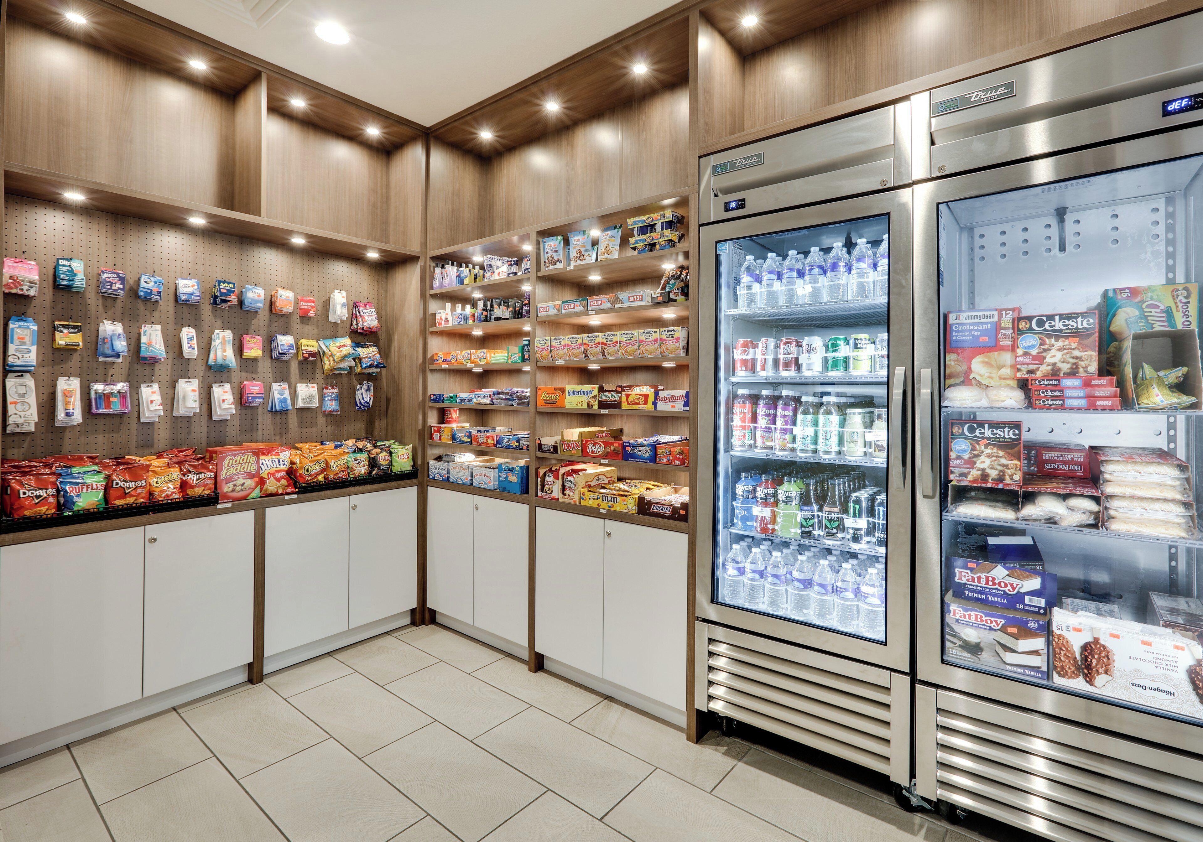 A grocery store interior with shelves stocked with snacks, beverages, and packaged goods.