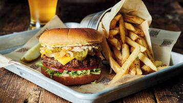 Un repas composé d’un hamburger et de frites, servi sur un plateau.