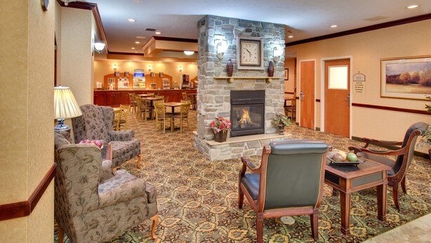 A lobby with a stone fireplace, seating area, and a reception desk. - Holiday Inn Express Hotel & Suites Bismarck by IHG (Bismarck)