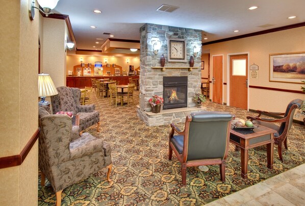 A lobby with a stone fireplace, seating area, and a reception desk. - Holiday Inn Express Hotel & Suites Bismarck by IHG (Bismarck)