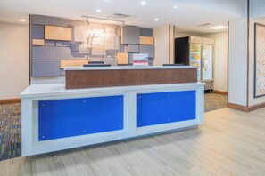 Un mostrador de recepción de diseño moderno, con una combinación de madera y paneles azules.