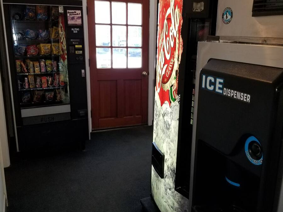 Zona de máquinas expendedoras con dispensador de Coca-Cola y de hielo.