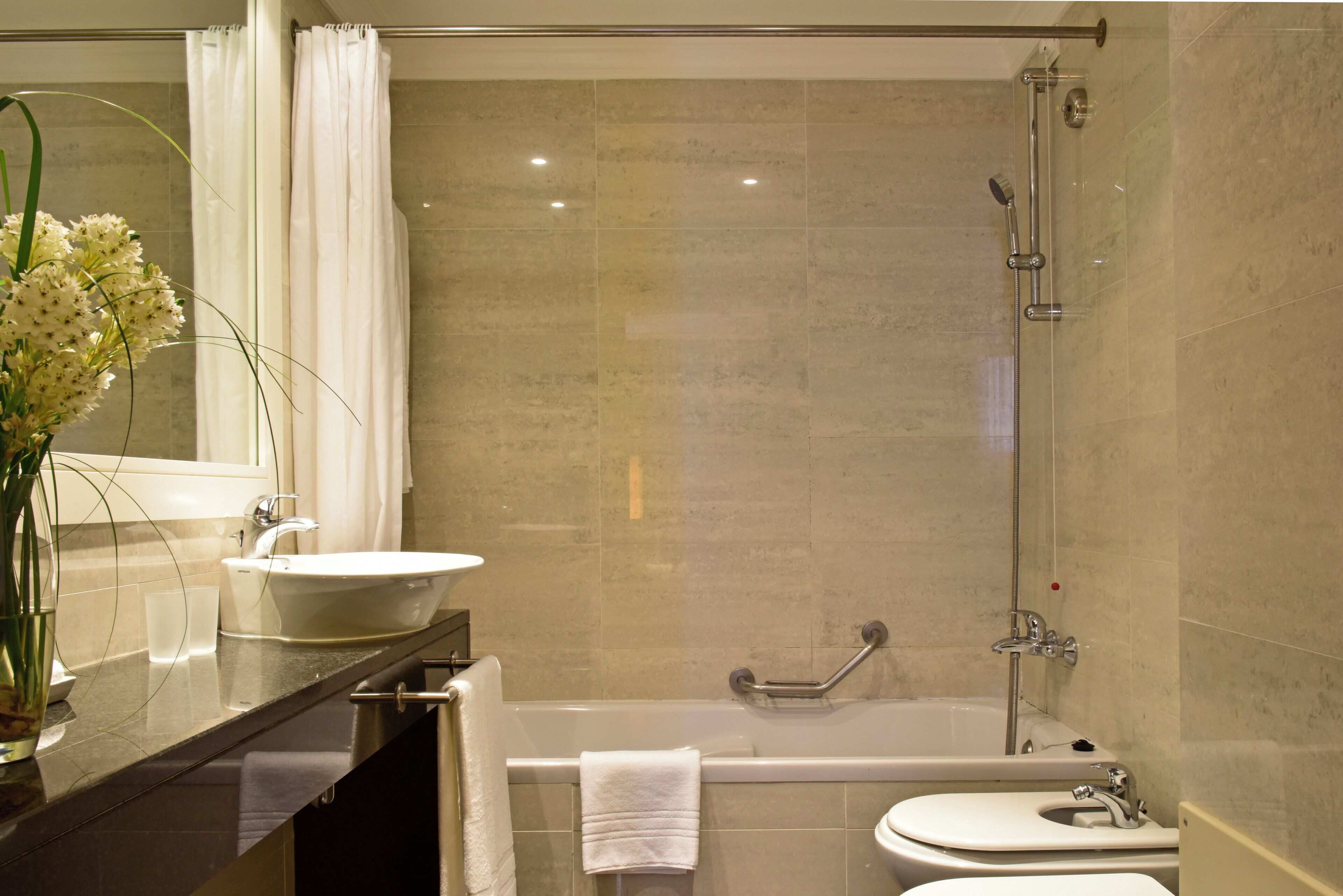 A bathroom with a sink, bathtub, and shower.