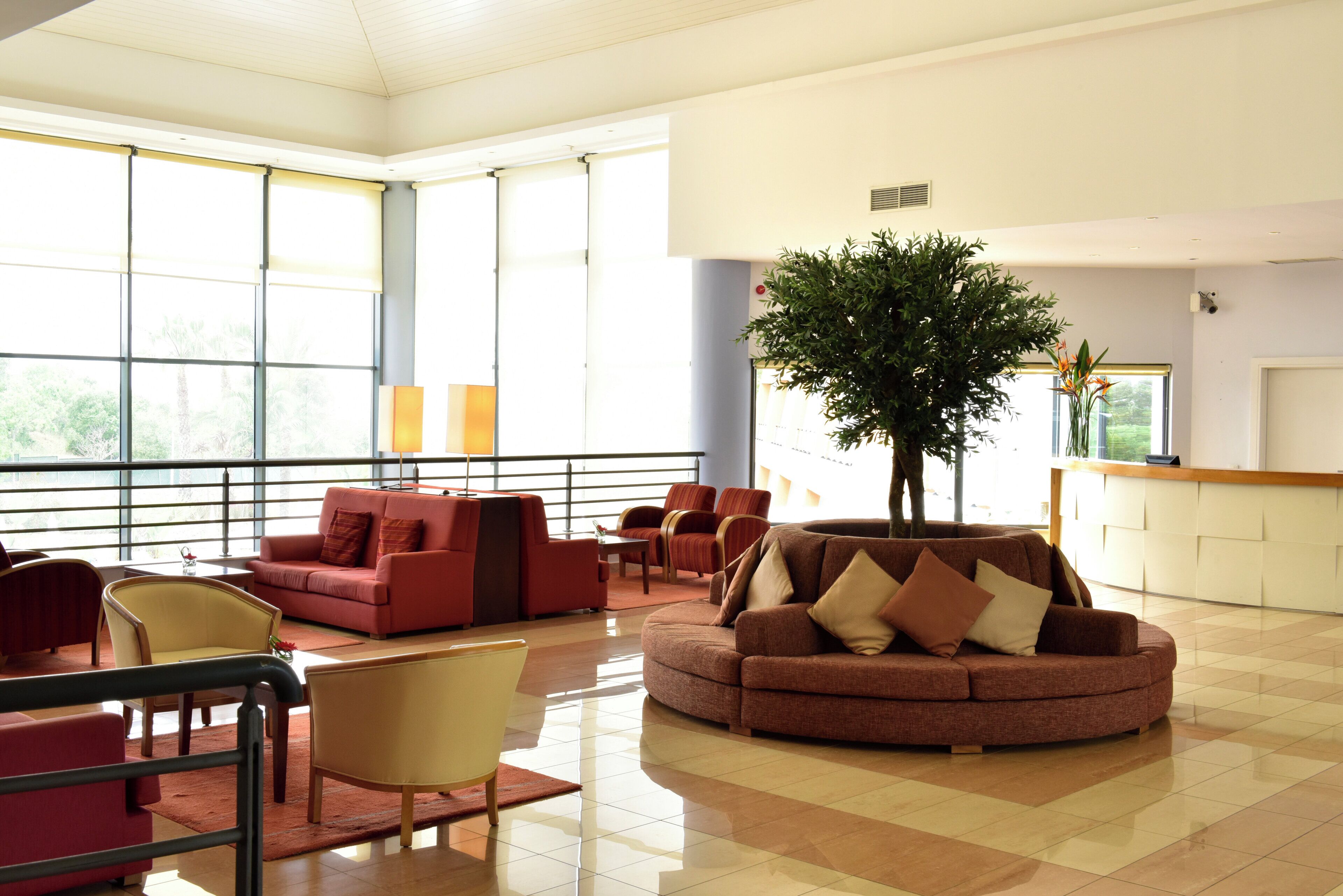 A spacious lobby with a large window, a reception desk, and a variety of seating options.