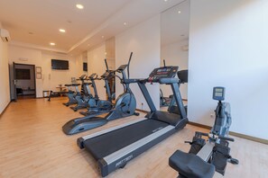 A gym with multiple treadmills, stationary bikes, and a rowing machine.